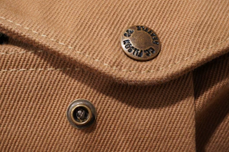 A close-up of a hand-thrown ceramic button on a colorful western dress, highlighting craftsmanship.