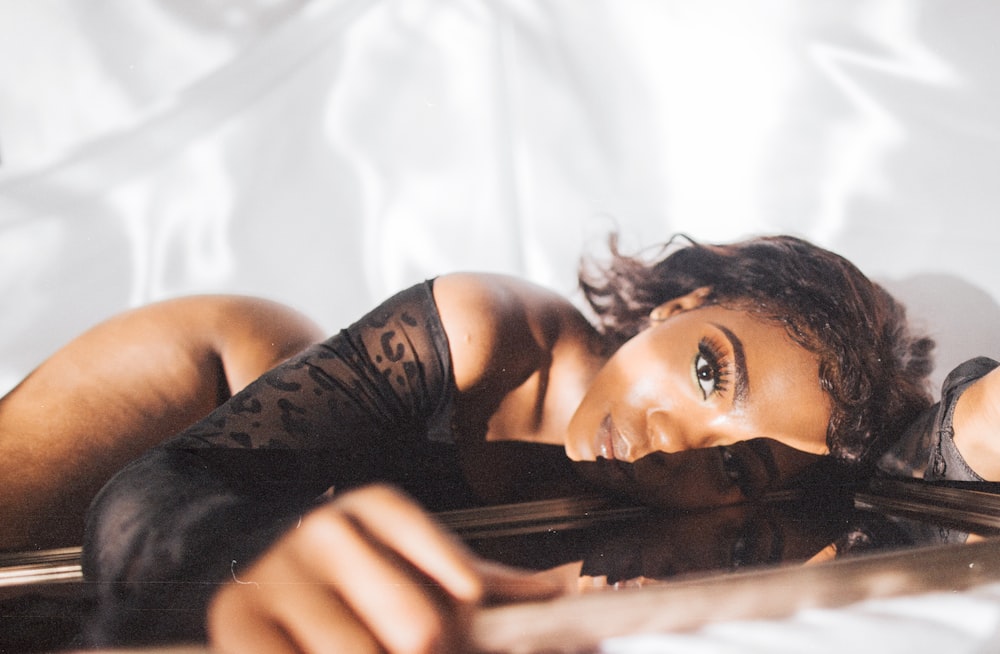 woman in black tank top lying on bed