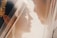 A close-up of a bride and groom gently facing each other under a soft veil, capturing a tender moment. The bride has golden leaf decorations in her hair.