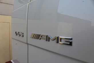 Metallic lettering displaying 'G63' and 'AMG' is prominently displayed on the side of a white vehicle, likely indicating a luxury car model.