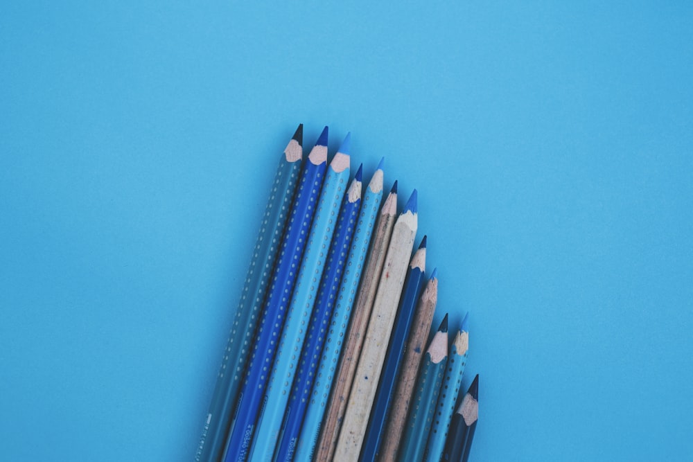 blue and white pencils on green surface