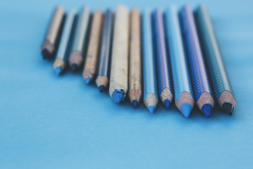 brown and gray pencils on teal surface