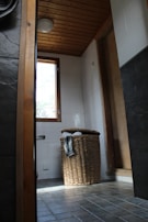 Natural light flooding a bathroom with wooden accents and fresh eucalyptus branches.