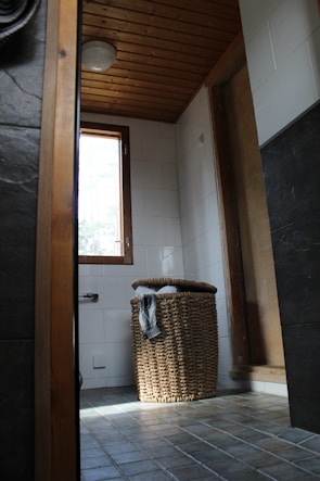 Bright bathroom with natural light highlighting elegant tile work and wooden accents.