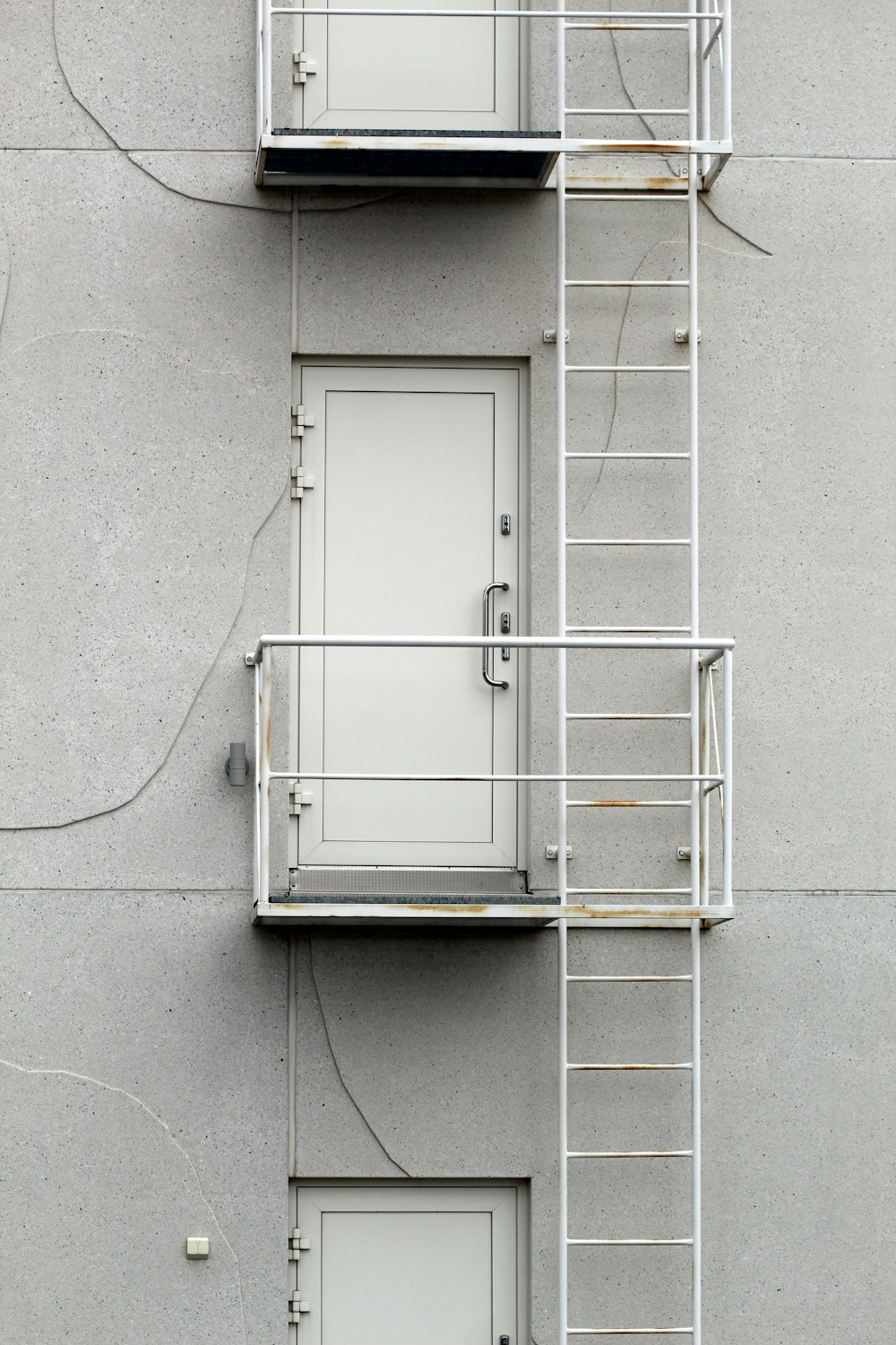 灰色のコンクリートの壁に白い金属製の窓枠
