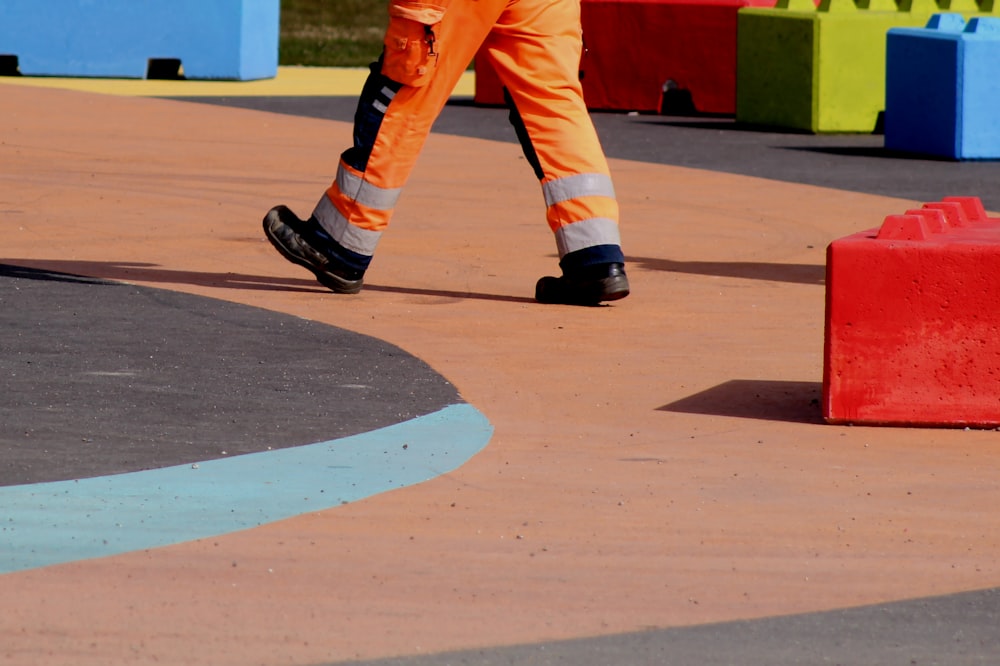 man in orange pants and black and white nike sneakers