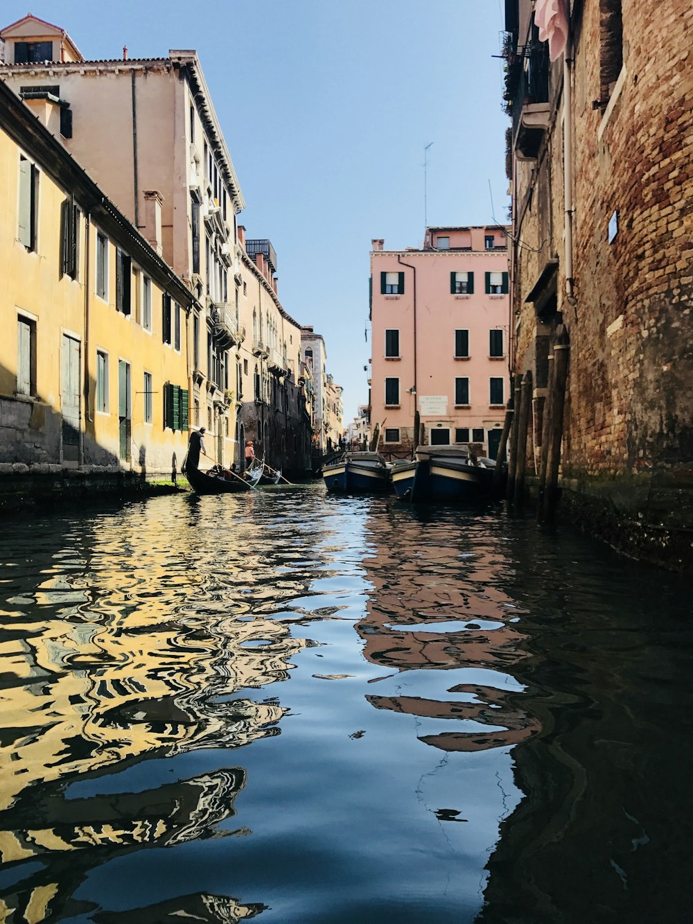 boat on river between buildings during daytime