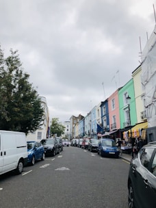 A bustling street view of Gulshan with colorful buildings and parked cars under a sunny sky.