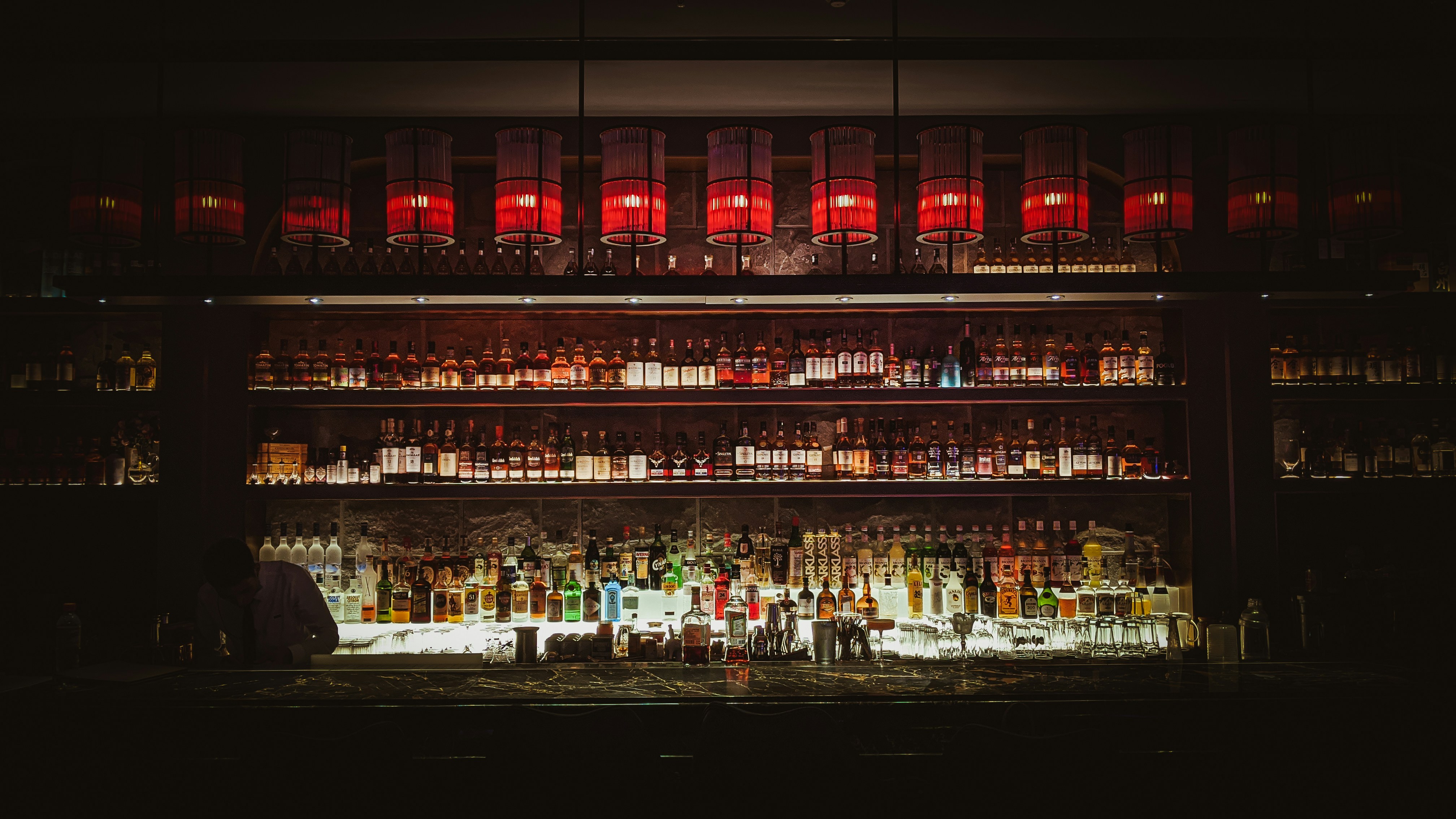 bottles on shelf with lights turned on during night time