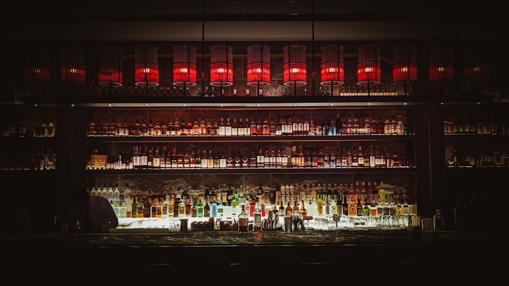 bottles on shelf with lights turned on during night time