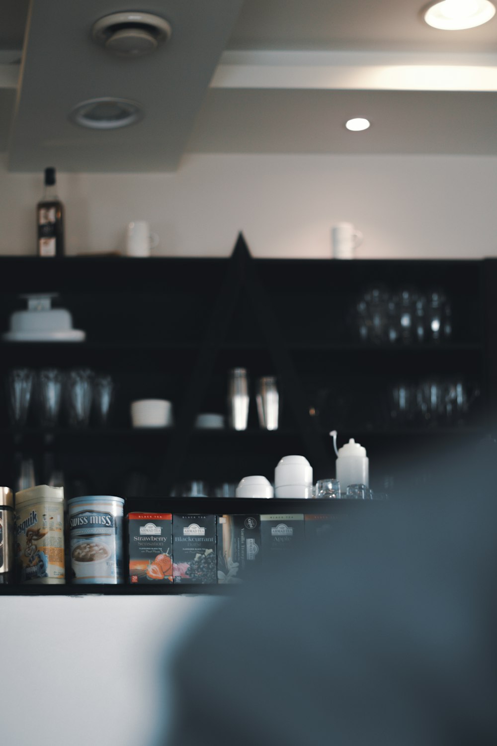 white and blue labeled bottle on black wooden shelf