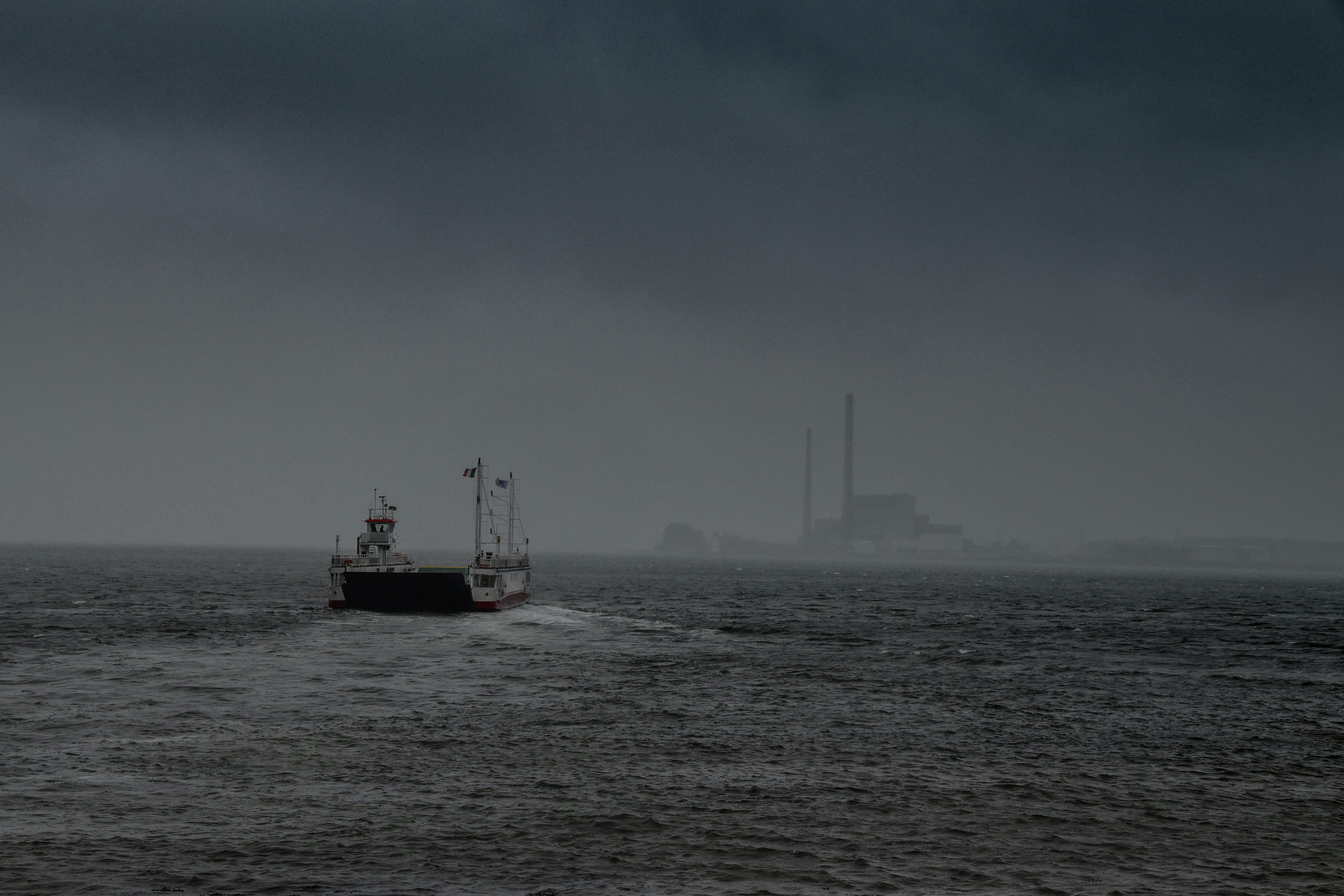 red and black boat on sea under white clouds during daytime