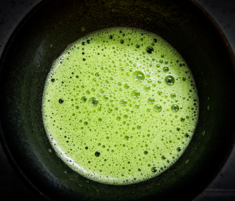 green liquid in black container