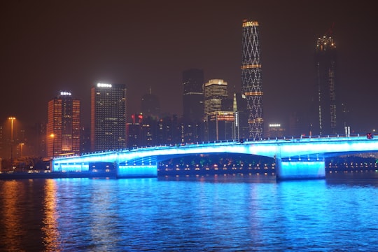 lighted bridge over water during night time in Guangzhou China