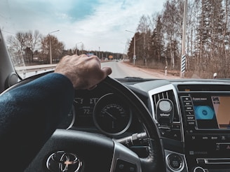 A confident driver taking a test drive on a suburban road with an instructor beside them.