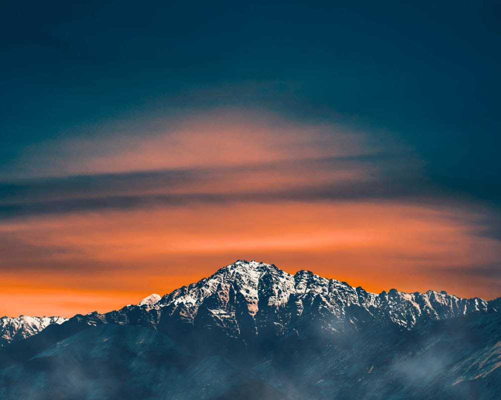 snow covered mountain during sunset