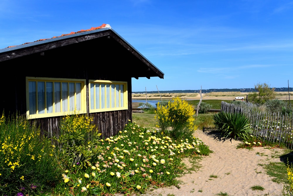 brown wooden house near green grass field under blue sky during daytime