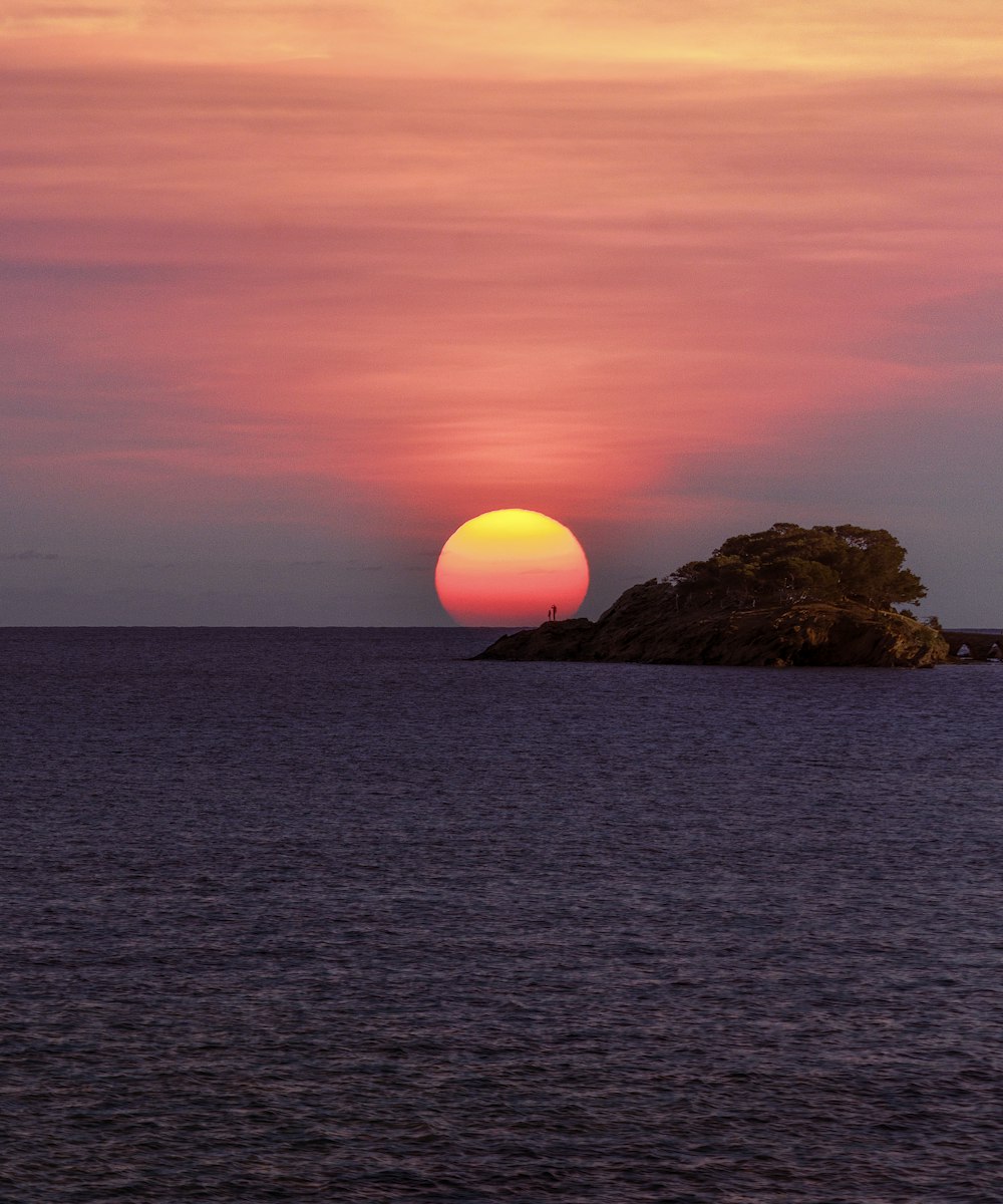 rock formation on sea during sunset