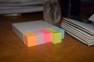 A neat stack of printed blog articles with colorful sticky notes marking important sections.