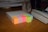 A neat stack of white copy paper next to colorful pens on a wooden desk.