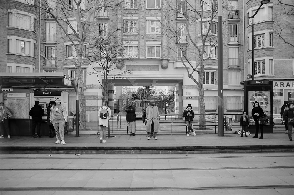 grayscale photo of people walking on sidewalk