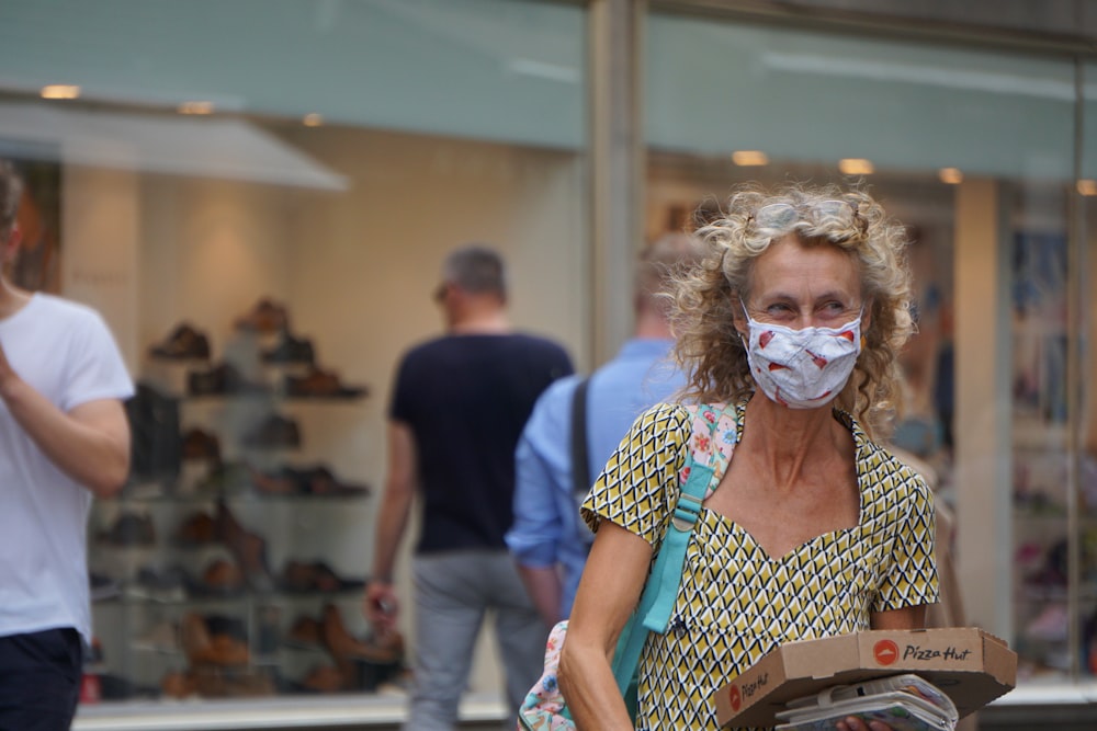 woman in white and black polka dot shirt wearing white mask