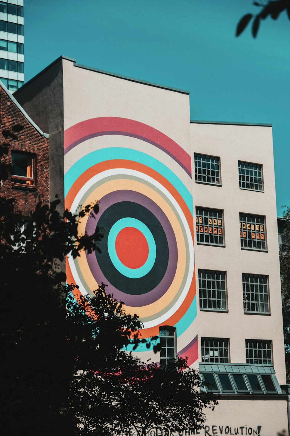 edificio rotondo in cemento bianco, rosa e blu