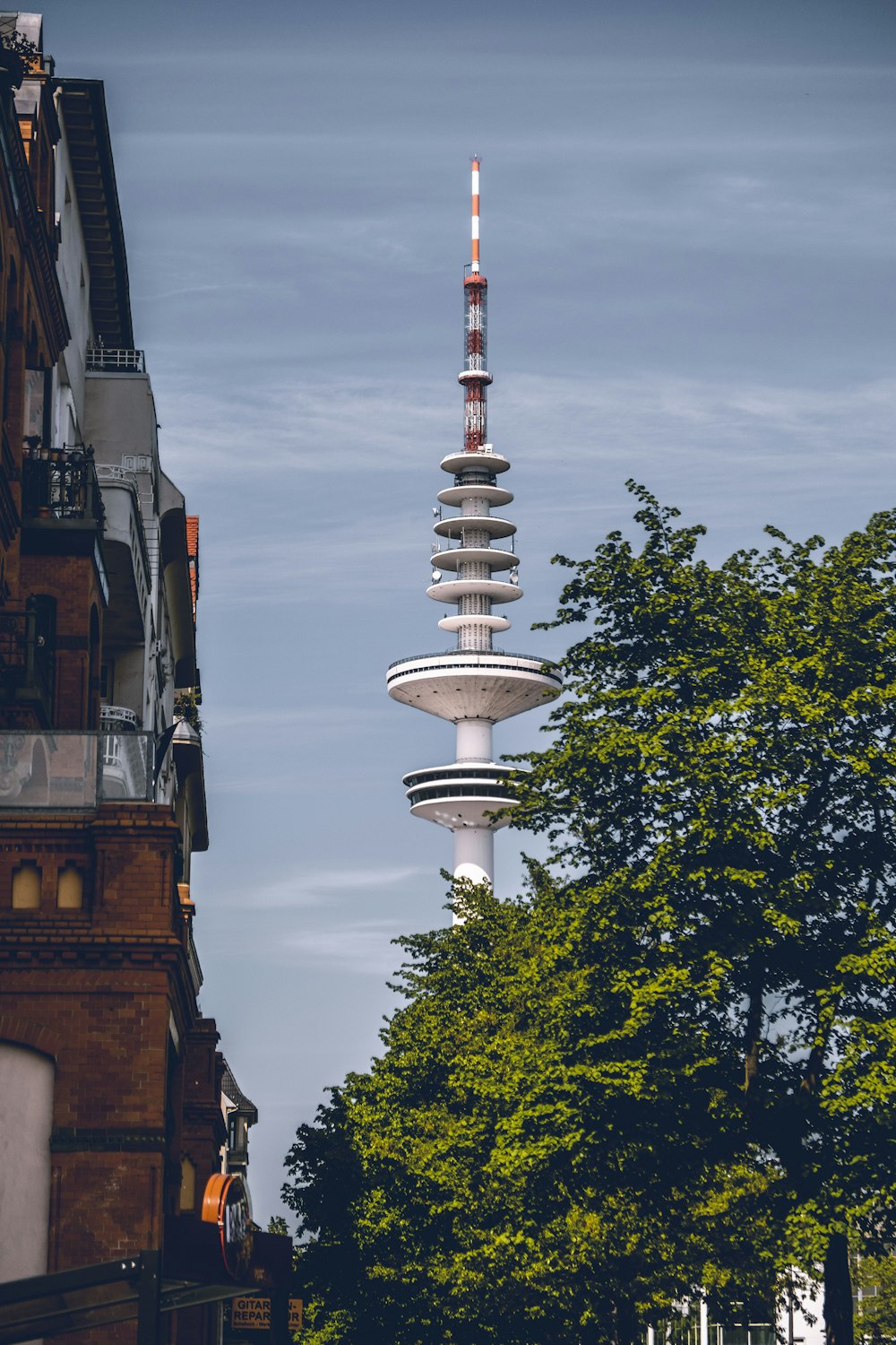 white and red tower near green trees during daytime