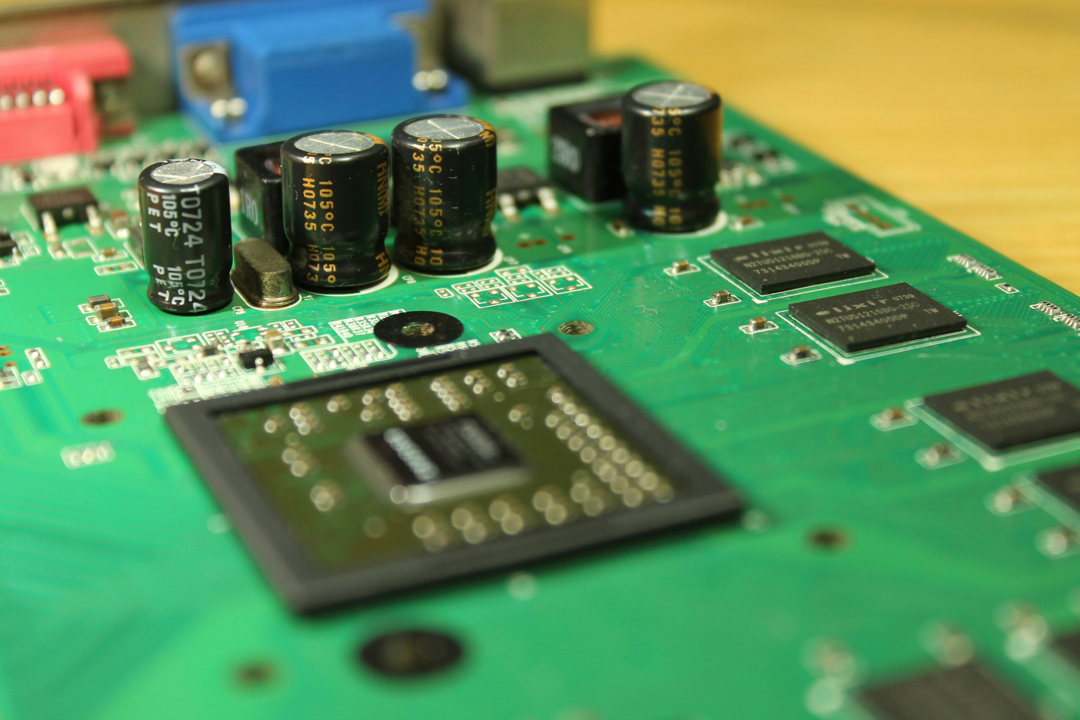 Circuit board and electronic components with green LED lights, dark background, technical hardware close-up