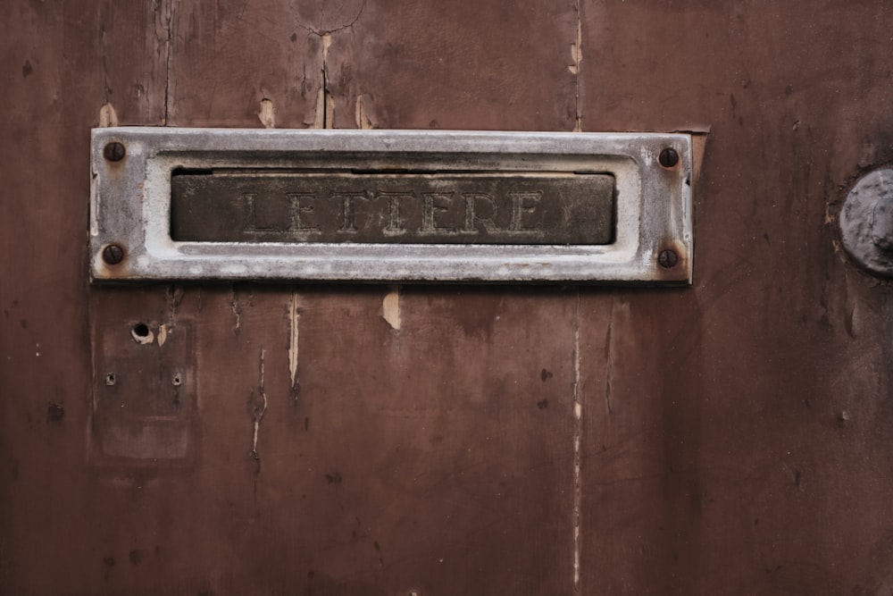 silver door handle on brown wooden door