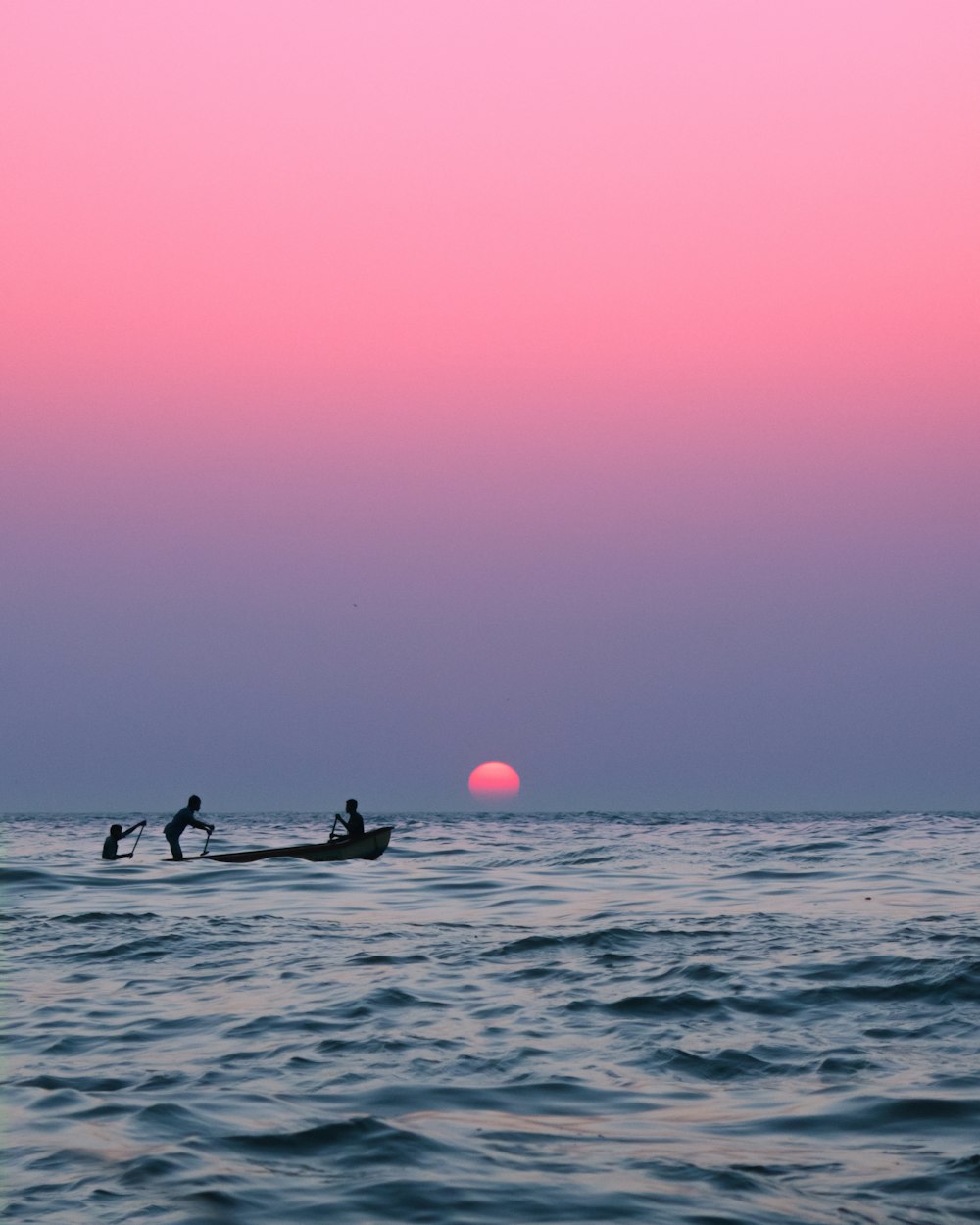 2 Personen fahren bei Sonnenuntergang auf dem Boot