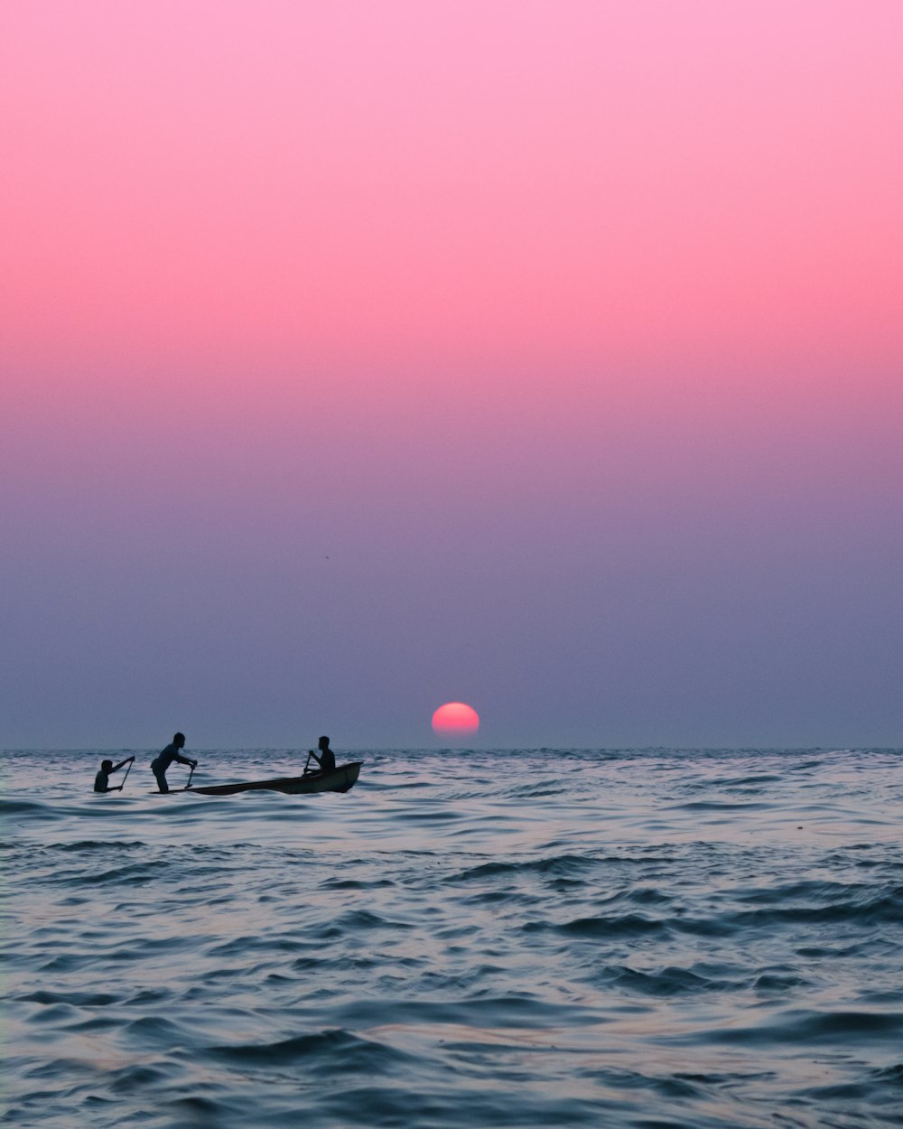 2 people riding on boat during sunset