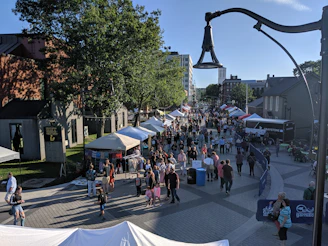 A bustling outdoor market scene with colorful stalls and happy shoppers enjoying a sunny Sunday morning.