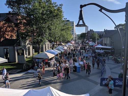 A vibrant street market bustling with local vendors and colorful stalls on a sunny day.