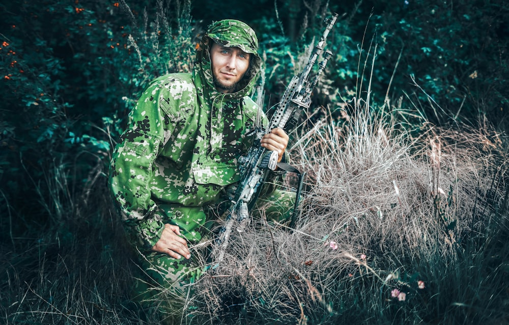 woman in green and black camouflage jacket holding black rifle