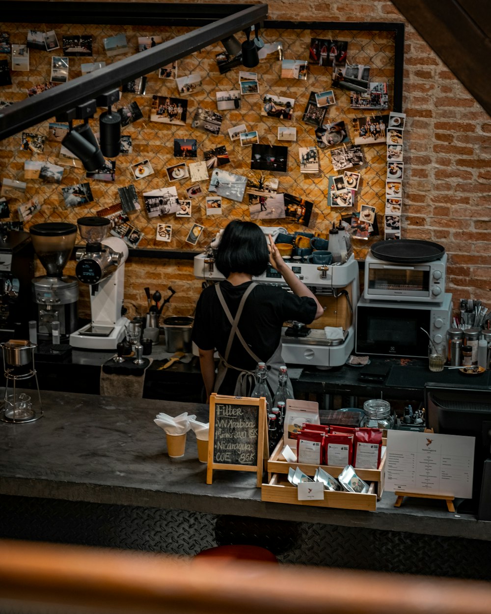 woman in black shirt standing in front of counter