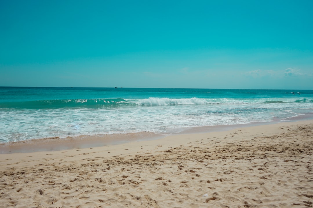sea waves crashing on shore during daytime, Beautiful tropical beach with waves and clear sky