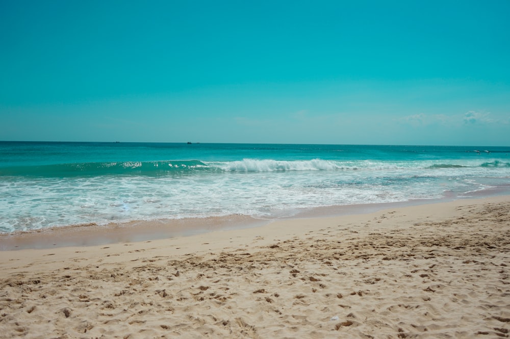 sea waves crashing on shore during daytime