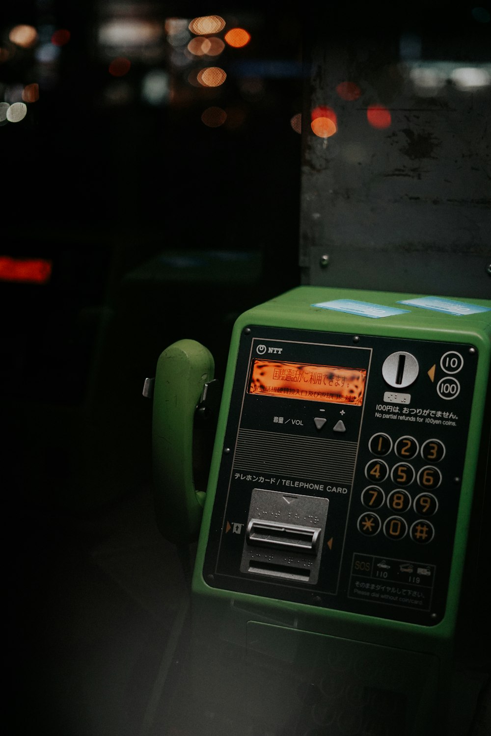 green telephone on brown wooden table