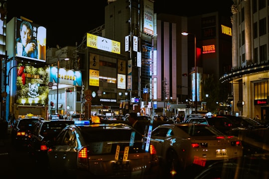cars on road near buildings during night time in Osaka Japan
