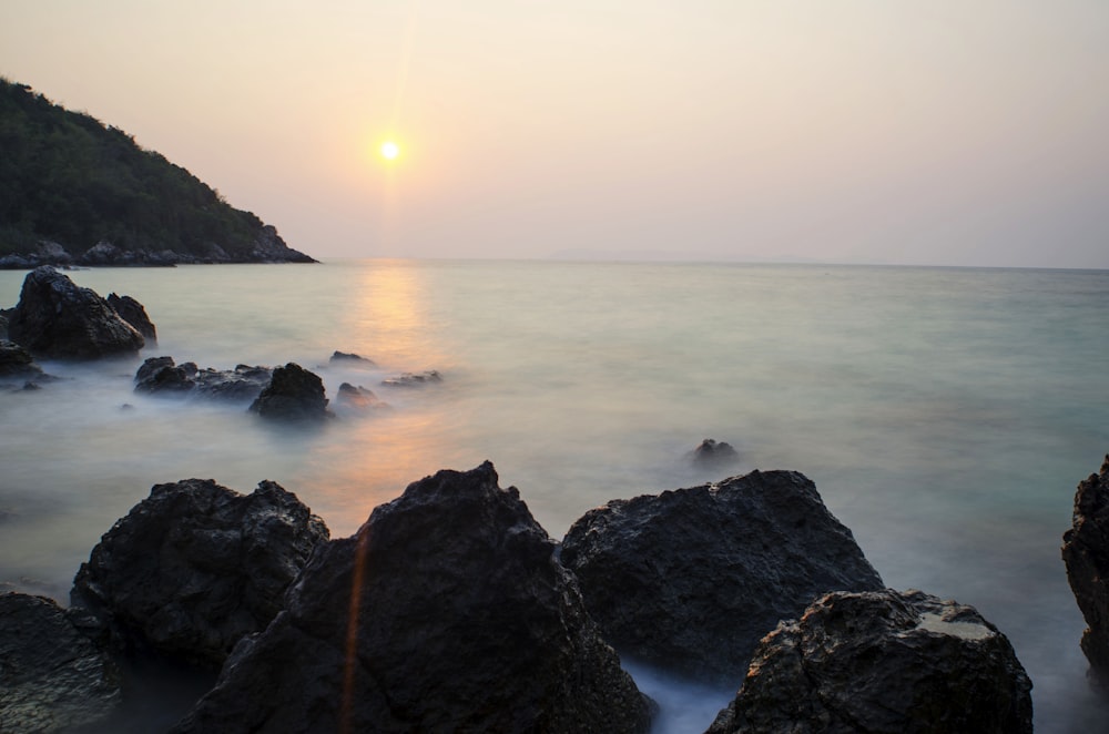 black rock formation near sea during daytime