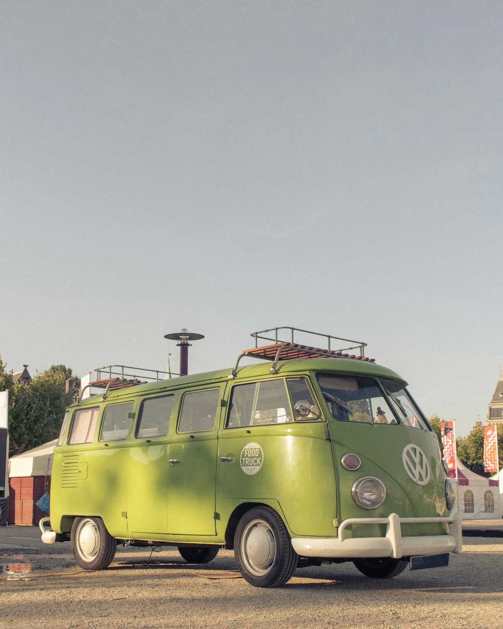 Fourgonnette Volkswagen T-2 verte garée sur une route en béton gris pendant la journée