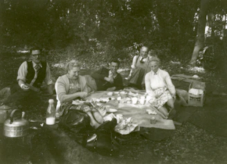 A group of veterans enjoying an outdoor picnic together, smiling and sharing stories.
