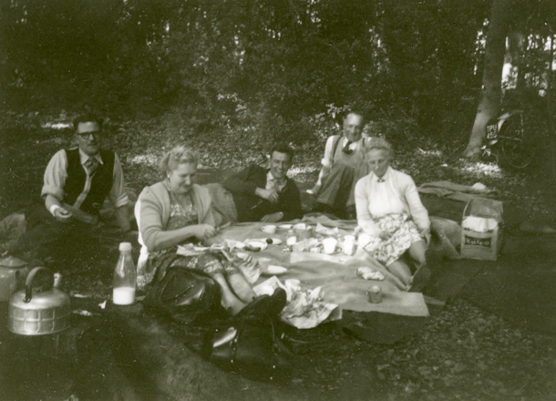 A group of veterans enjoying an outdoor picnic together, smiling and sharing stories.
