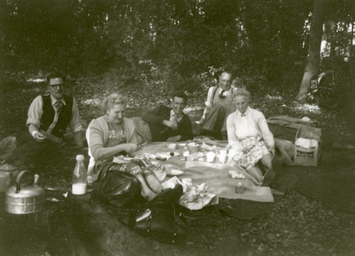 A group of friends enjoying a picnic with various outdoor gear.