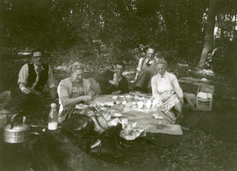 grayscale photo of people sitting on ground