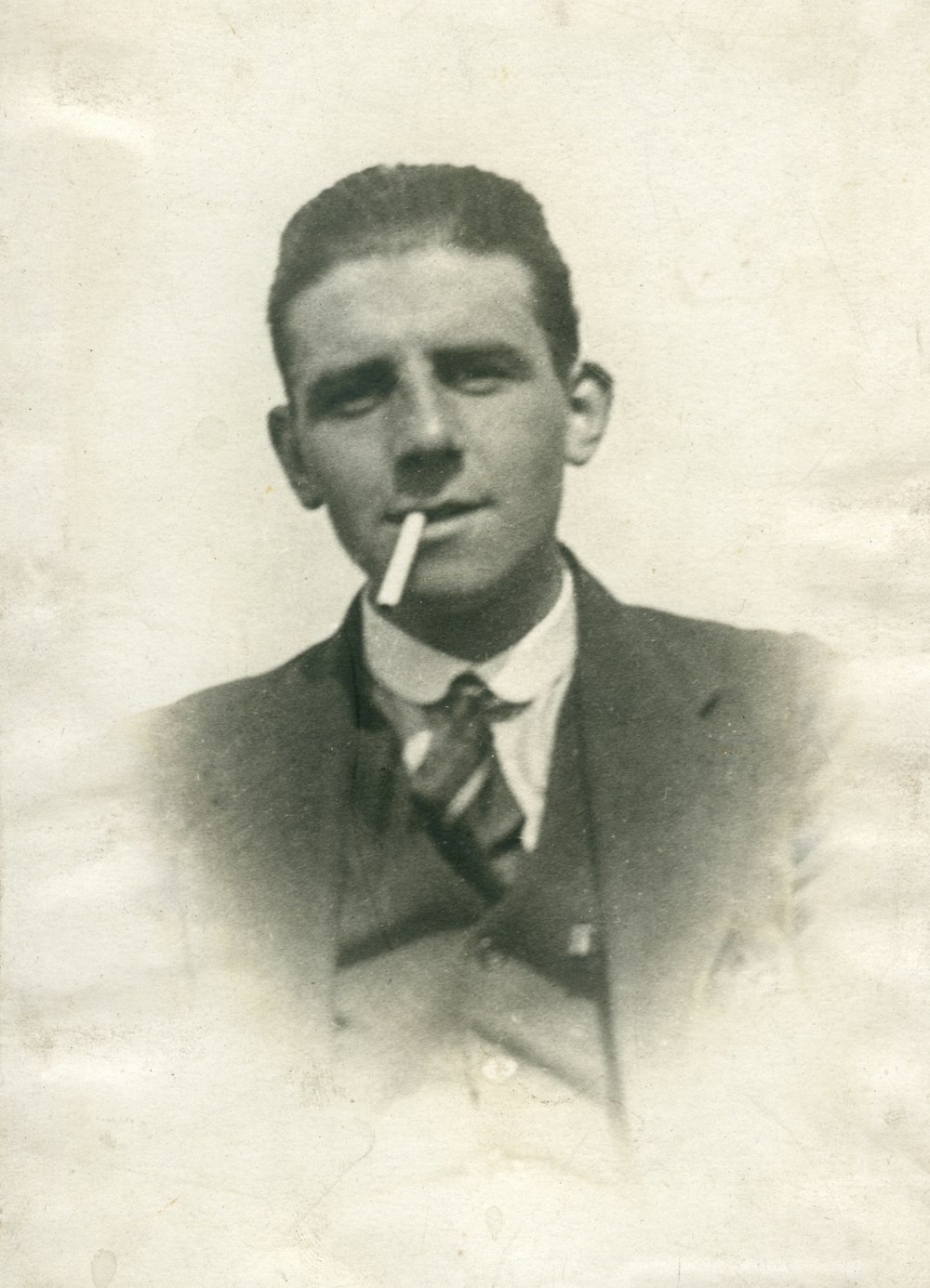 man in suit jacket smoking cigarette