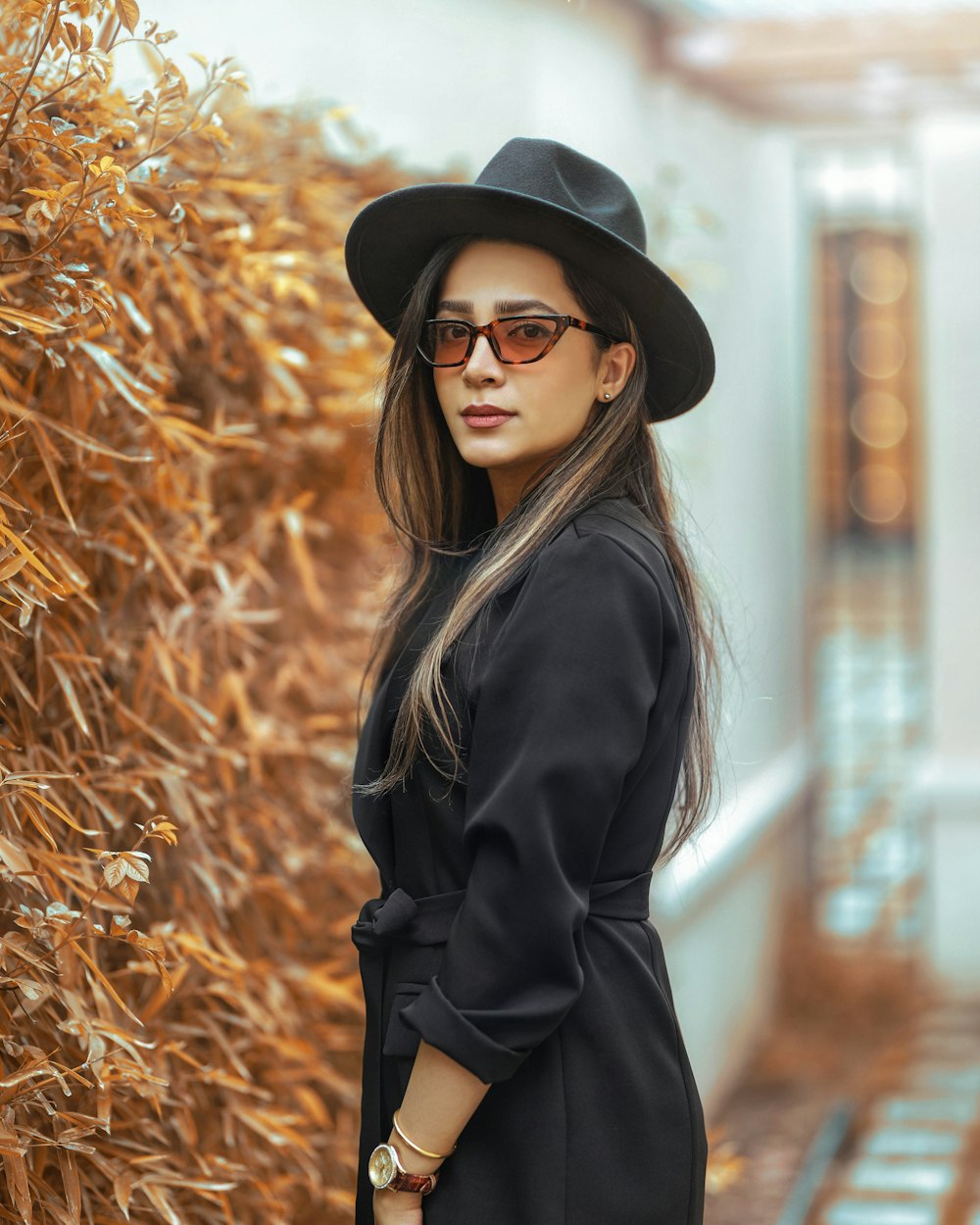 woman in black coat standing on brown grass field during daytime