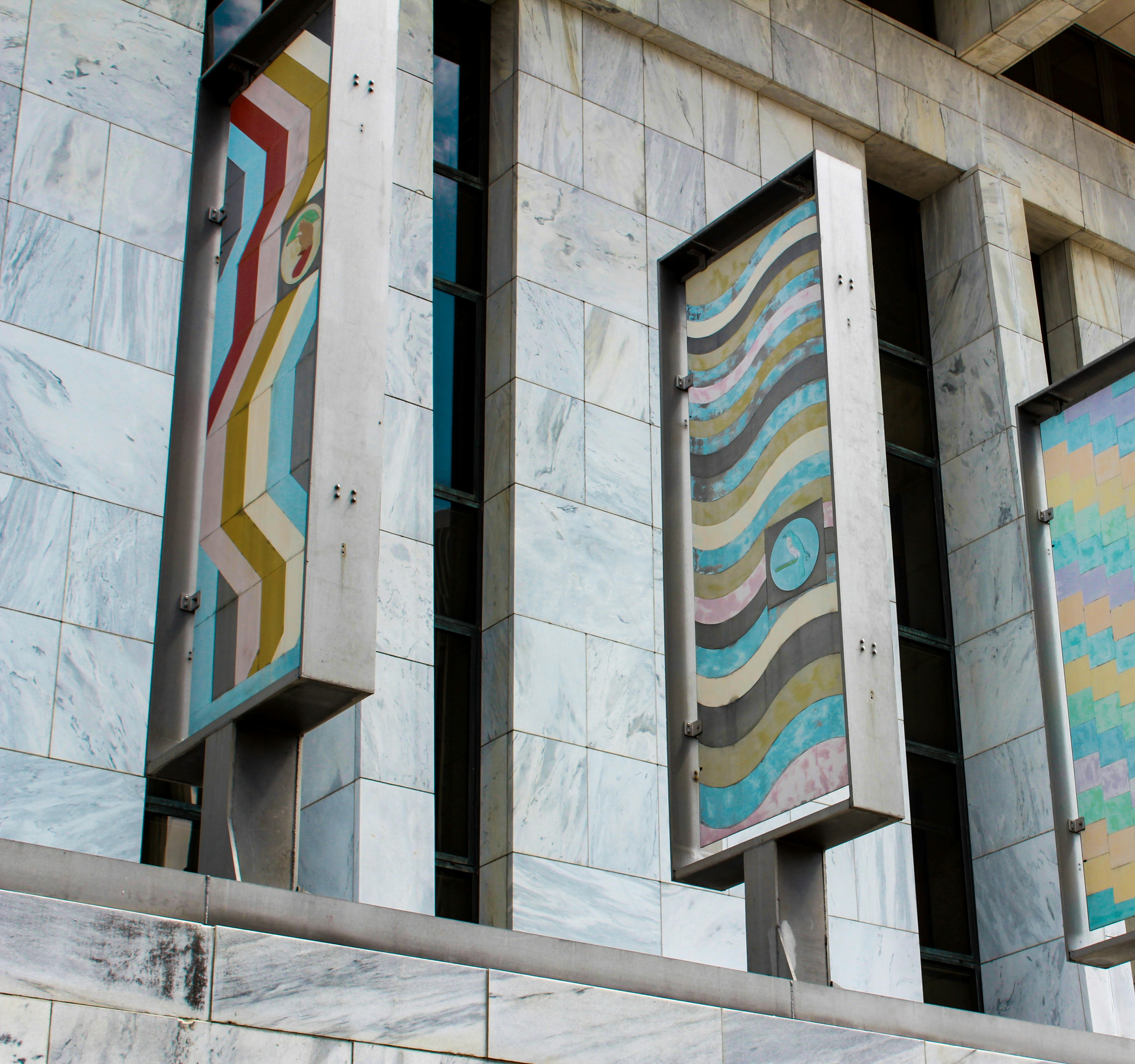 Pintura abstracta azul, blanca y roja sobre pared de hormigón blanco