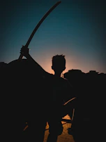 Silhouettes of warriors in historic armor standing against a twilight sky.